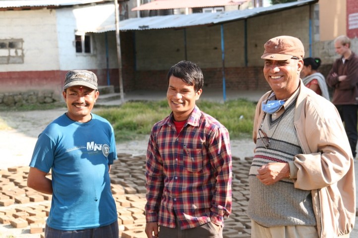 Von links: Santa Kaji (angehender Ofenbauer), der Ofenbauer-Trainer und Damodar Karki (Regional Coordinator) vor der Himalaya Boarding School in Budhanilkanth, Nepal.