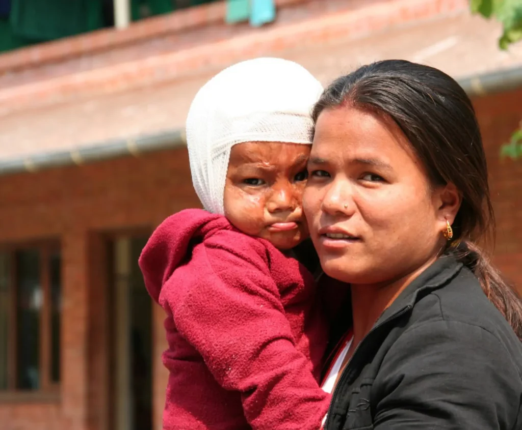 Mutter mit Kind vor dem SKM Hospital in Kathmandu