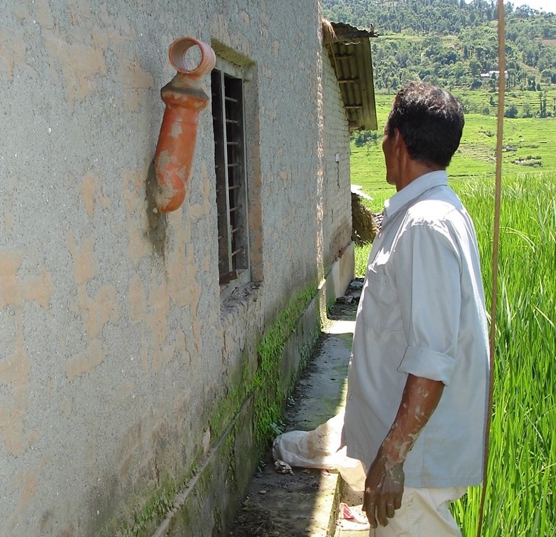 An der Außenwand eines Hauses ist das Endrohr eines Ofens zu sehen.